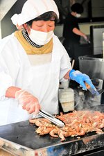 【匂いに誘われ】
大量のモサエビを鉄板で焼く関係者。香ばしい匂いに誘われて行列がどんどん伸びていく