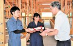 完成した牛舎の鍵を西村徹副町長（右）から受け取る奥沢さん（左）と村田さん＝２９日、新温泉町丹土