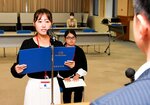 交付式でボランティア活動への決意を述べる松岡さん（左）