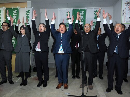 ３選を決め支援者らと万歳する竹口さん（中央）＝１３日午後９時１０分、大山町西坪