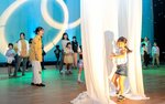 宇宙空間に見立てたステージを楽しむ親子連れら