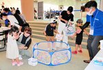 七つの間違い探しに正解し、お菓子釣りに挑戦する親子連れ＝１７日、倉吉未来中心