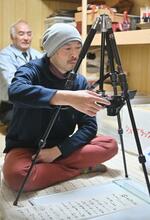 　福島県浪江町の住宅で古文書を撮影する国文学研究資料館教授の西村慎太郎さん＝１月