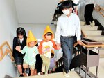 手をつないで校舎の階段を上る高校生と園児