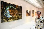 日南町で撮影したオオサンショウウオの写真と福田さん＝６日、日南町霞の町美術館