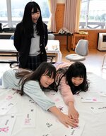 メンバー手作りの英語かるたを取り合う子どもたち＝３日、日野町黒坂の旧黒坂小