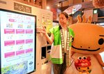 ふるさと納税自販機をＰＲする赤坂英樹副町長とミササラドン＝１２日、鳥取県三朝町三朝の三朝温泉観光商工センター