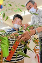 住民と一緒に短冊をくくり付ける児童＝５日、鳥取市卯垣２丁目の稲葉山小