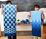 藍染めのタペストリーを手にする西山代表理事（右）と柴田さん＝２４日、智頭町智頭の藍染工房ちずぶるー