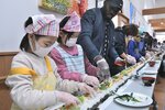 長さ３３メートルの恵方巻き作りに励む参加者ら＝３日、鳥取市西今在家の東郷地区公民館