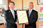 平井知事（左）から取り組みをたたえられ、賞状を受け取る坪倉理事長