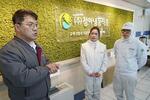 　韓国・永川市の食品加工会社で、ベトナム出身のグイン・ヌ（中央）ら外国人従業員と話す常務の鄭慶鎬（左）＝２月（共同）