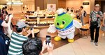 梨売り場で来店客にポーズを取るトリピー