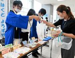 来場者に商品を手渡す生徒（左）