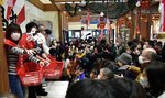 年男、年女ら（左）が福豆をまくと、手を広げて歓声を上げながら拾い集める参加者＝２８日、岩美町新井の道の駅きなんせ岩美