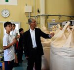 小林社長（中央）の案内で精米所を見学する参加者＝３０日、若桜町若桜の若桜農林振興