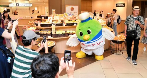 梨売り場で来店客にポーズを取るトリピー