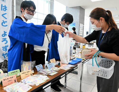 来場者に商品を手渡す生徒（左）