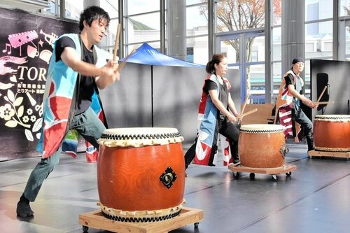 力強いばちさばきで太鼓を響かせる岩美龍神太鼓のメンバーら＝２６日、とりぎん文化会館