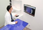 診察台で機器を操作する村井院長