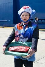 　「関鯨丸」から荷揚げされたナガスクジラの生肉を手に取材に応じる共同船舶の所英樹社長＝２日午前、仙台港