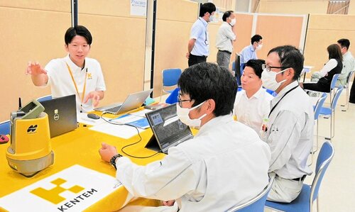 来場者に製品を紹介するメーカー担当者（左）