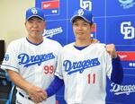　支配下選手に復帰し、記者会見で井上監督（左）と握手する中日・岡田＝１日、バンテリンドーム