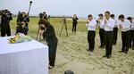 　大蔵海岸で献花し、手を合わせる丸谷聡子明石市長（手前左）と幹部職員ら＝２６日午前、兵庫県明石市