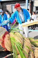 【お清め】綱引き開始前、綱を菖蒲酒で清める祭りの関係者。鏡開きも４年ぶりに復活した