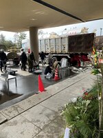寺谷建材のタンクから給水する被災者ら＝石川県志賀町の同町文化ホール（寺谷さん提供）