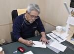 　再度移転した仮設工房で沈金の図案を描く藤野孝一郎さん