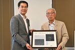 命名記念額を受け取る長谷氏の長男・収さん（右）＝３０日、鳥取市役所