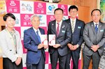 西村町長（左から２人目）に図書カードを手渡す西谷専務理事（同３人目）＝１０日、新温泉町役場