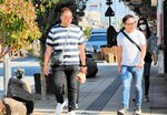 半袖で水木しげるロードを歩く観光客＝２日、境港市松ケ枝町