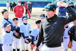 子どもたちにボールの投げ方を教える金刃さん