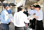 自転車に乗る際のヘルメット着用や施錠を呼びかける生徒会役員ら＝１５日、鳥取市湖山町北２丁目の鳥取商業高