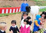 ポニーの玉三郎に見守られて自己紹介する入園児ら＝１１日、鳥取市越路大谷