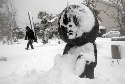 雪に埋もれる水木しげるロードの妖怪ブロンズ像＝24日午前10時18分、境港市大正町