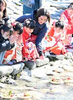 願いを託した流しびなに手を合わせて送り出す子どもら＝３１日、鳥取市用瀬町の千代川