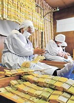 色とりどりのかき餅を丁寧に編み上げる地元住民ら＝１２日、鳥取県智頭町西宇塚