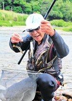 友釣りでアユを釣り上げた組合員＝２７日、香美町香住区の大乗寺橋下