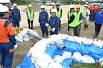 土のうを積む工法訓練の様子＝１８日、鳥取市西品治の千代川河川敷