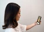 　資生堂の「ＡＩスキンアナライザー」を実演する社員＝２０２４年１１月、東京都港区で撮影
