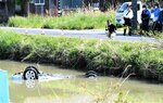 乗用車が川に転落、転覆した現場を調べる捜査員ら＝１４日、鳥取市福部町細川の塩見川
