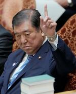 　衆院予算委の集中審議で答弁のため手を挙げる石破首相＝１４日午前