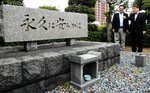 玉栄丸爆発事故の現場近くにある慰霊碑を見る根平さん（右）と十河さん＝１５日、境港市大正町