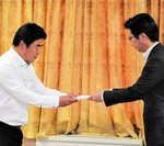 伊木市長（右）から申し入れ書を受け取る足利所長＝１２日、米子市役所