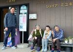 　豊鉄バスがグループホームに寄贈した「バス停」で、談笑する入居者と施設長の武田誠さん（左端）＝２０２５年３月、愛知県豊橋市