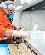 水流式塗装ブースでフィギュアパーツを塗装する従業員＝２７日、倉吉市河北町のグッドスマイルカンパニー望月工場