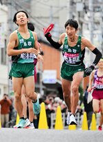 ６区大本（左）からたすきを受けて力走するアンカーの岡本＝第６中継所